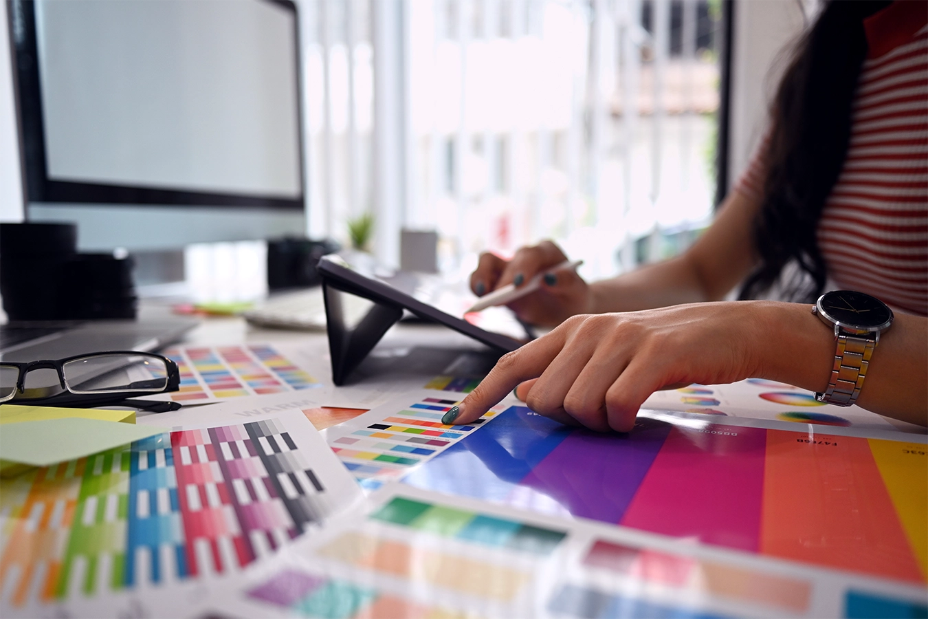 Equipe Luzativo seleciona paleta de cores com guias e tablet durante a criação da identidade visual da Autivina.